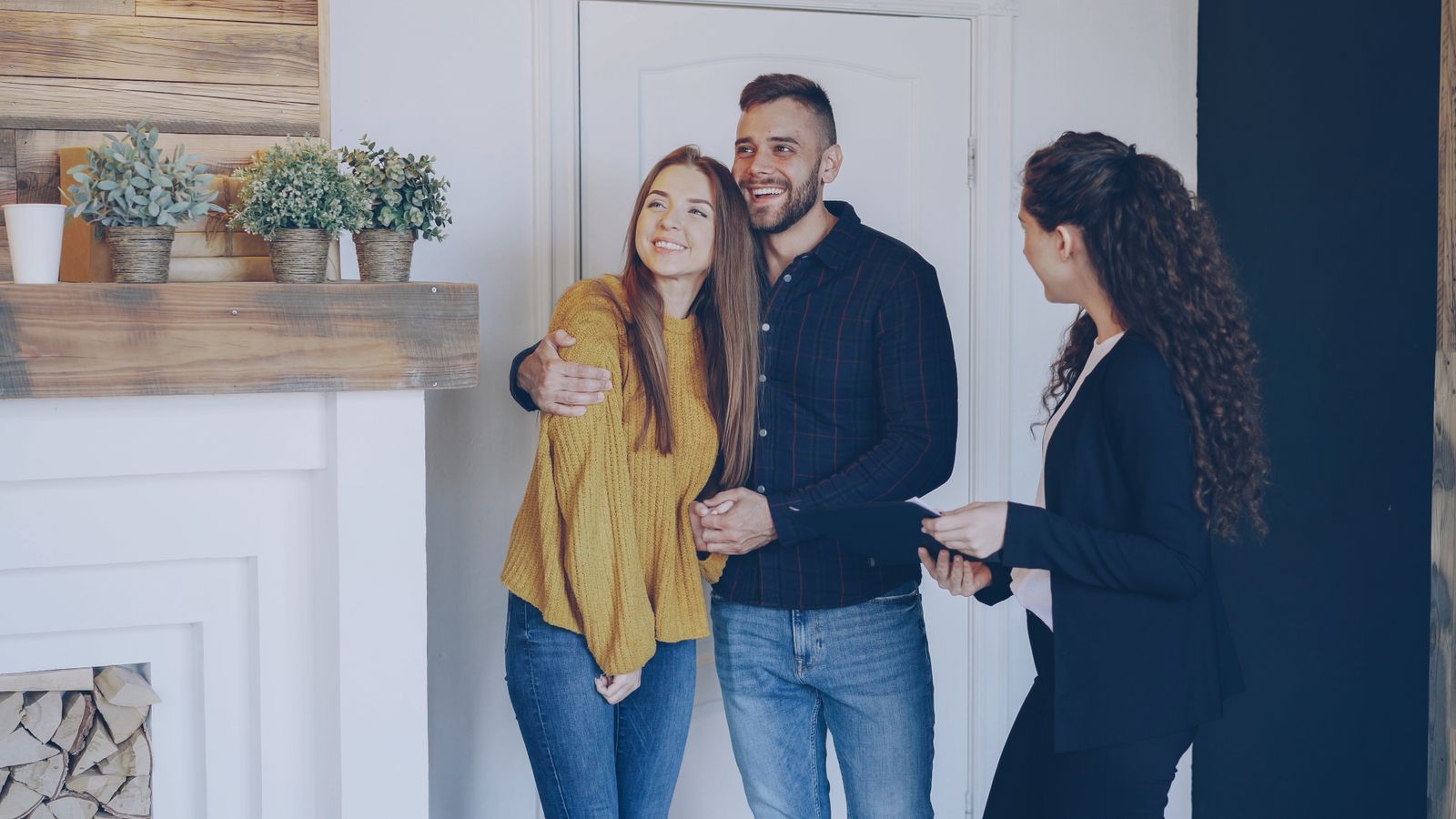 Couple comparant des offres de prêt immobilier devant un ordinateur avec calculatrice et clés de maison